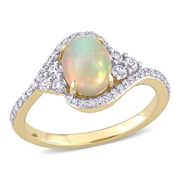 1 ct tgw ethiopian yellow opal, white sapphire and 1/5 ct tw diamond oval halo twist ring in 10k yellow gold